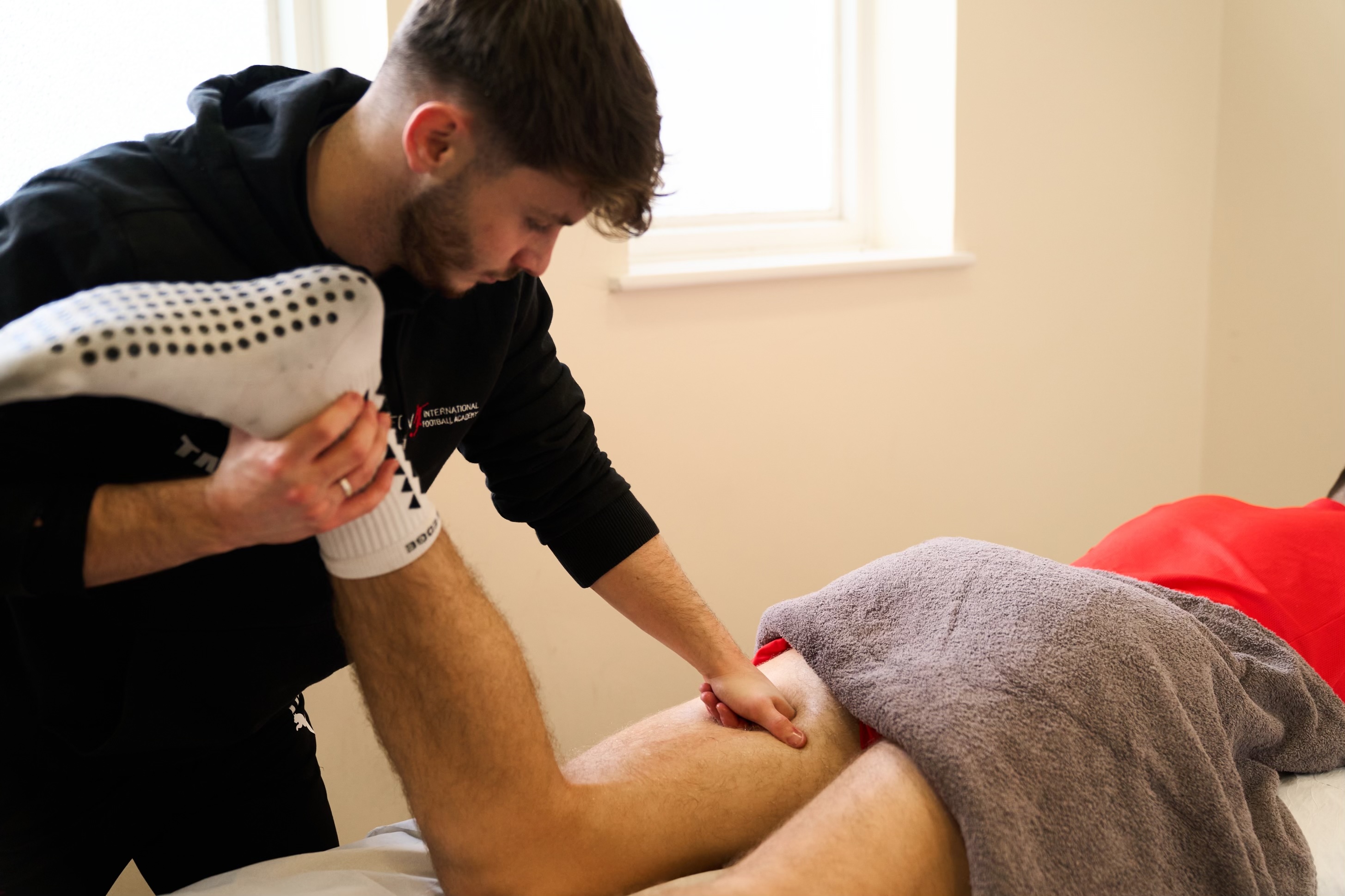 Sports therapist performing treatment on an athlete